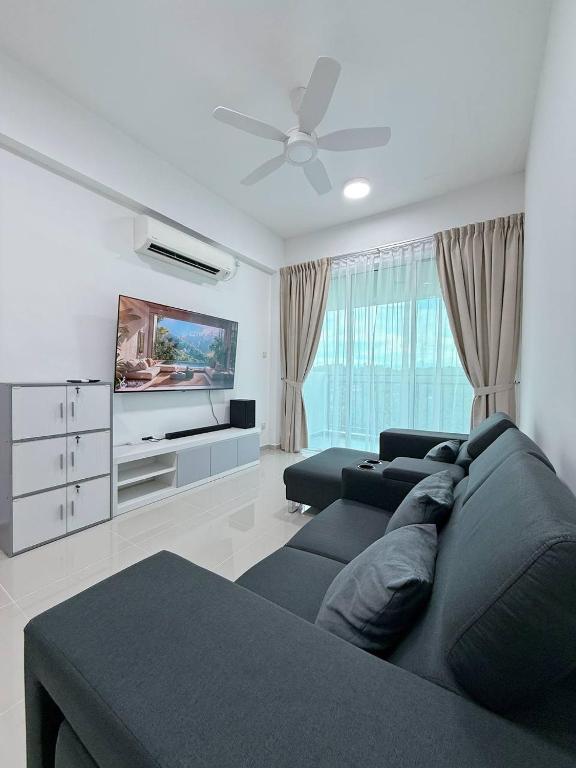 a living room with a couch and a flat screen tv at Sri Indah The Eleventh 5pax in Sandakan