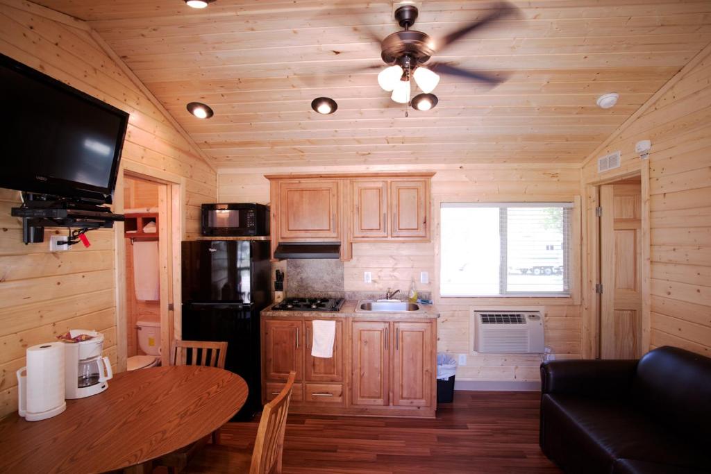 a kitchen with wooden cabinets and a ceiling fan at Soledad Canyon Wheelchair Accessible Cottage 16 in Ravenna