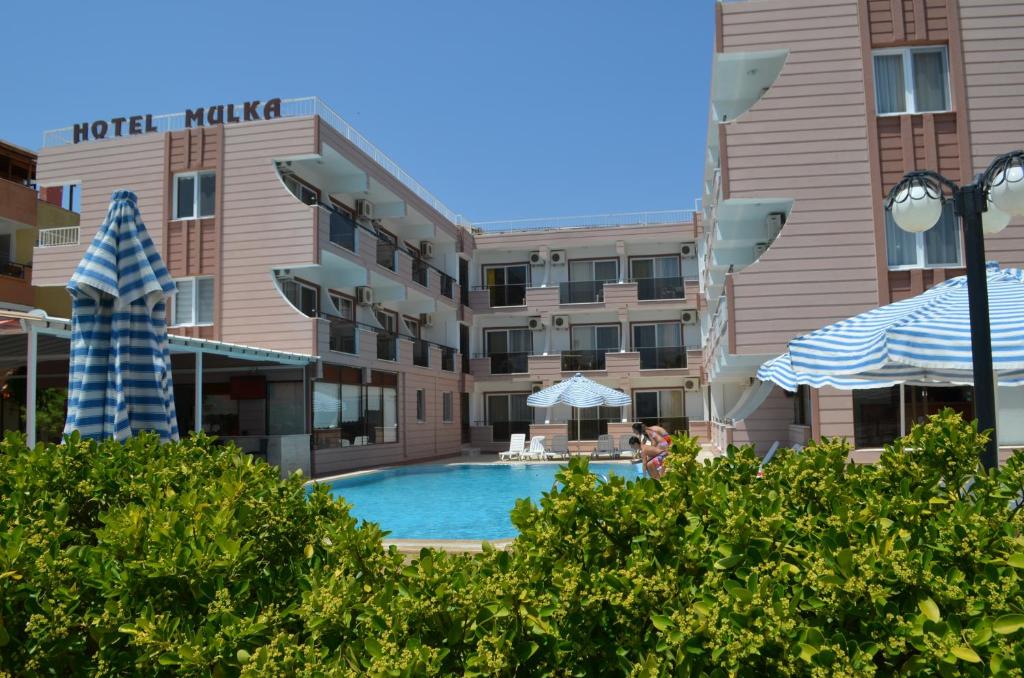 a hotel with a pool in front of a building at Mulka Hotel in Ayvalık