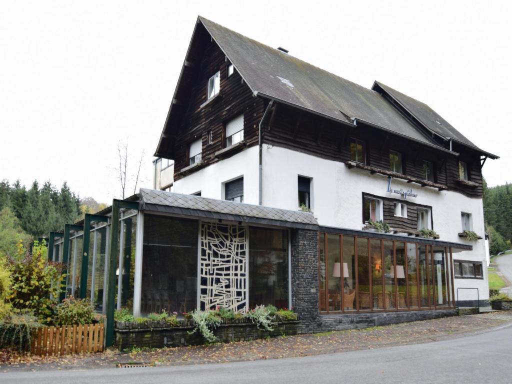 a large white building with a black roof at Pet-Friendly Escape in Fauvillers in Fauvillers
