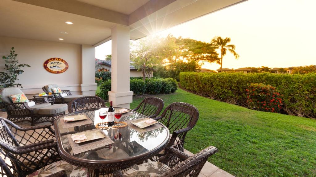 a patio with a table and chairs on a lawn at COCONUT TELEGRAPH Rejuvenating 3BR Villages Home Near Recreation Center in Waikoloa