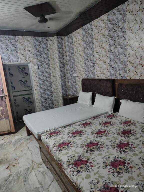 a bedroom with a large bed with flowers on the wall at Shri Raghunandan dham in Chitrakoot