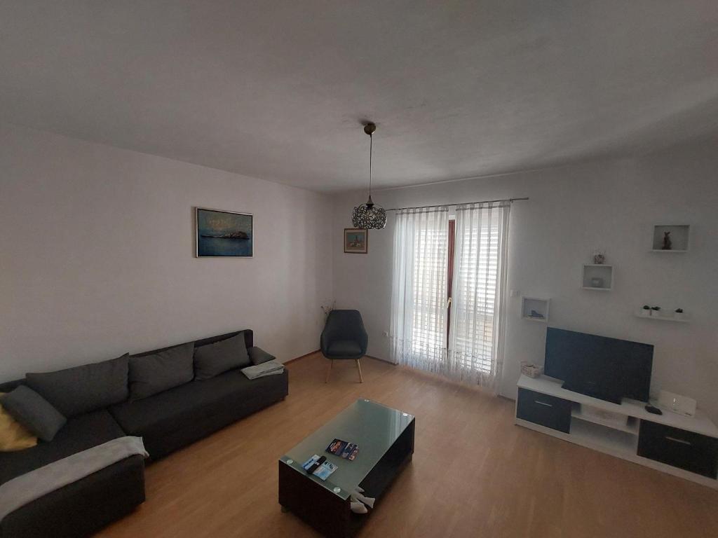 a living room with a couch and a tv at Apartment Dominik - Two Bedroom Apartment with Terrace and Sea View in Smokvica
