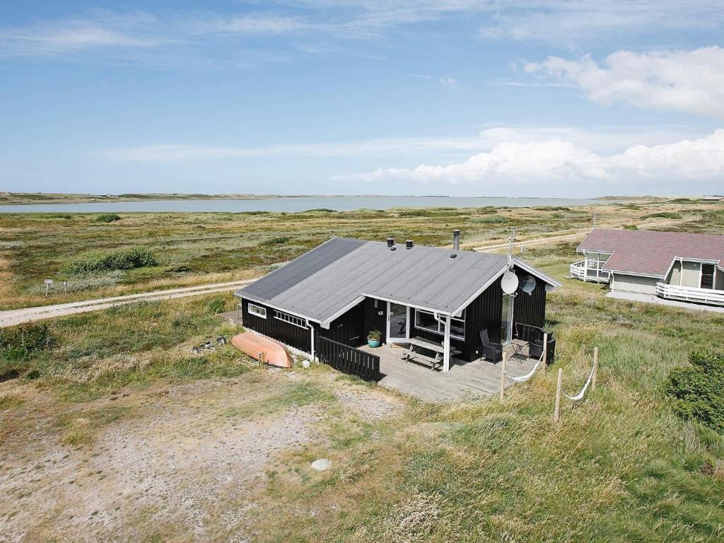 a black house in the middle of a field at 6 person holiday home in Lemvig-By Traum in Trans