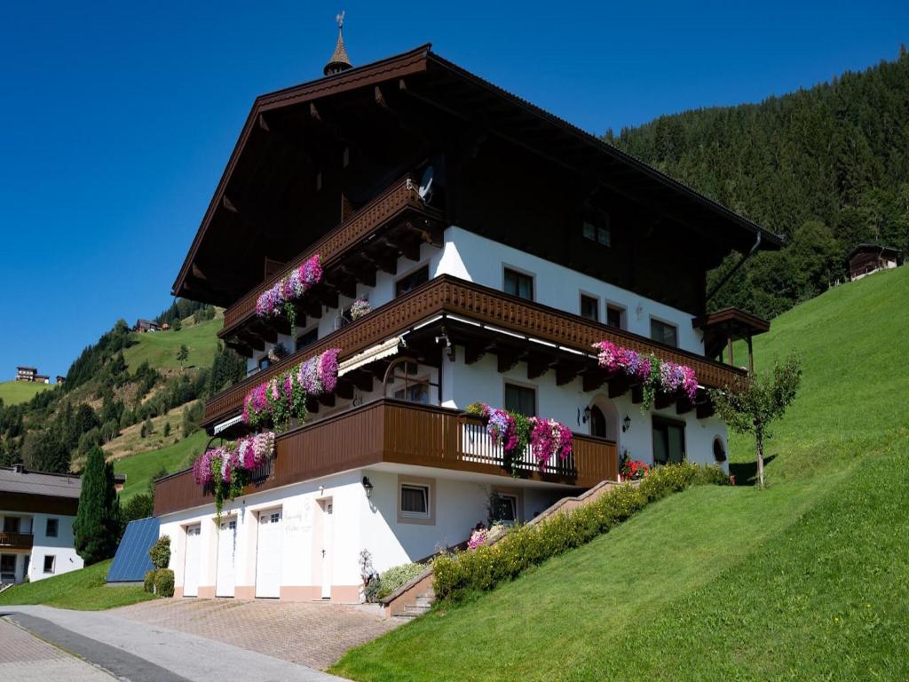 a house with flowers on the balconies on a hill at Apartment in Hollersbach near Ski Slopes in Bramberg am Wildkogel