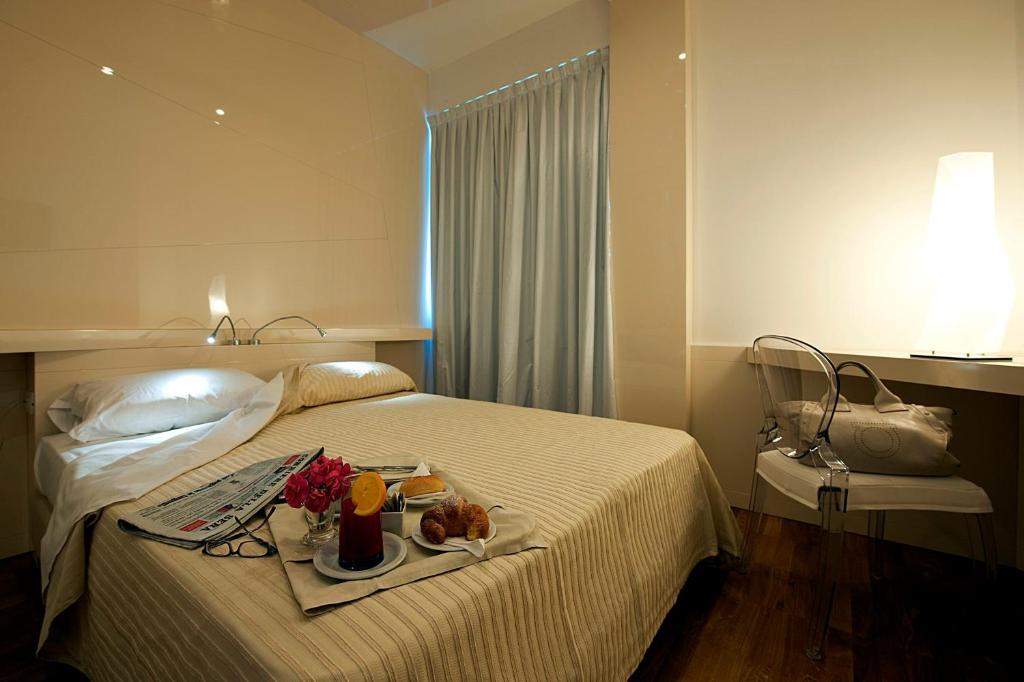 a hotel room with a bed with a tray of food on it at Hotel Excelsior in Vasto