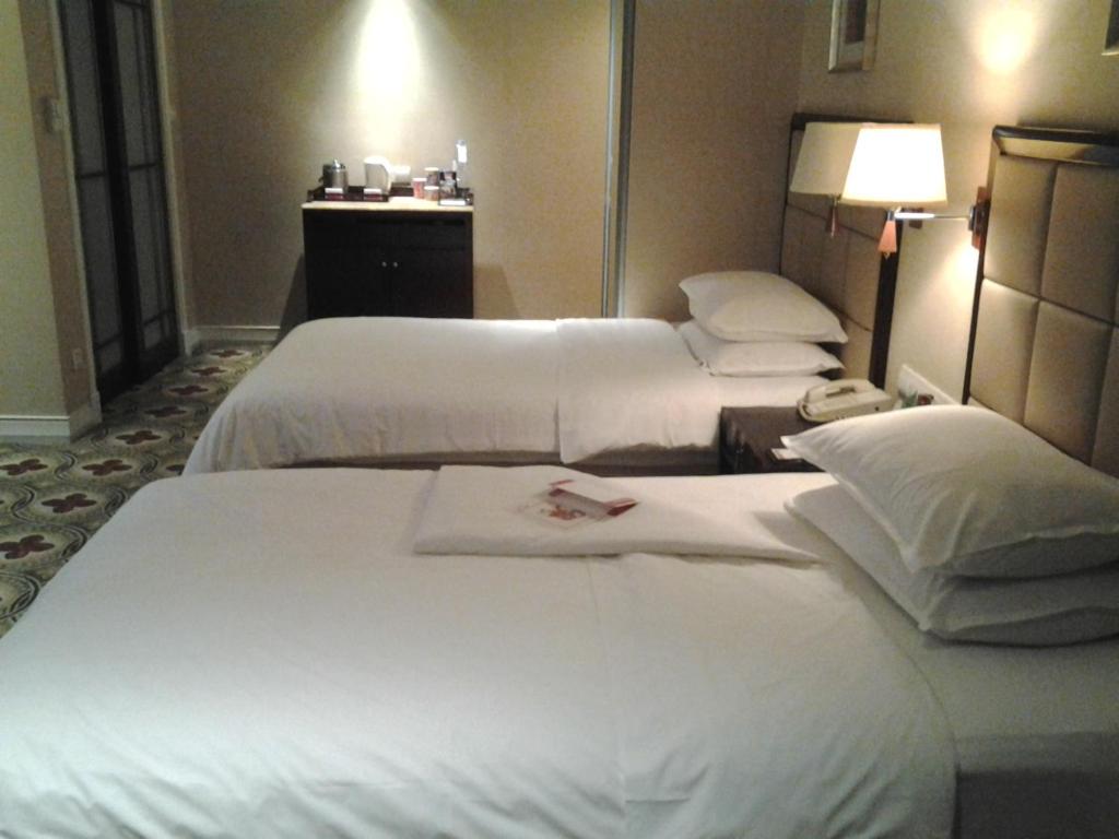 Postel nebo postele na pokoji v ubytování Ramada Plaza Optics Valley Hotel Wuhan (Best of Ramada Worldwide)