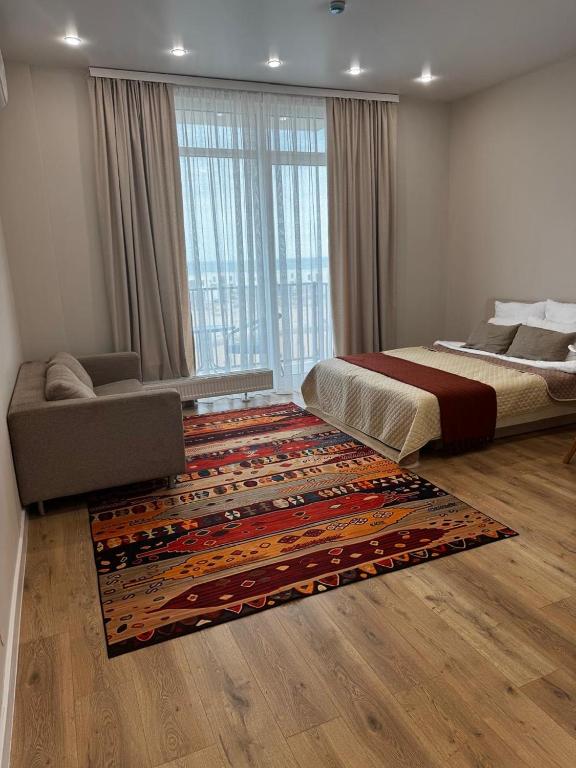 a bedroom with a bed and a large rug at Апартаменты Aktau Rivera in Aktau