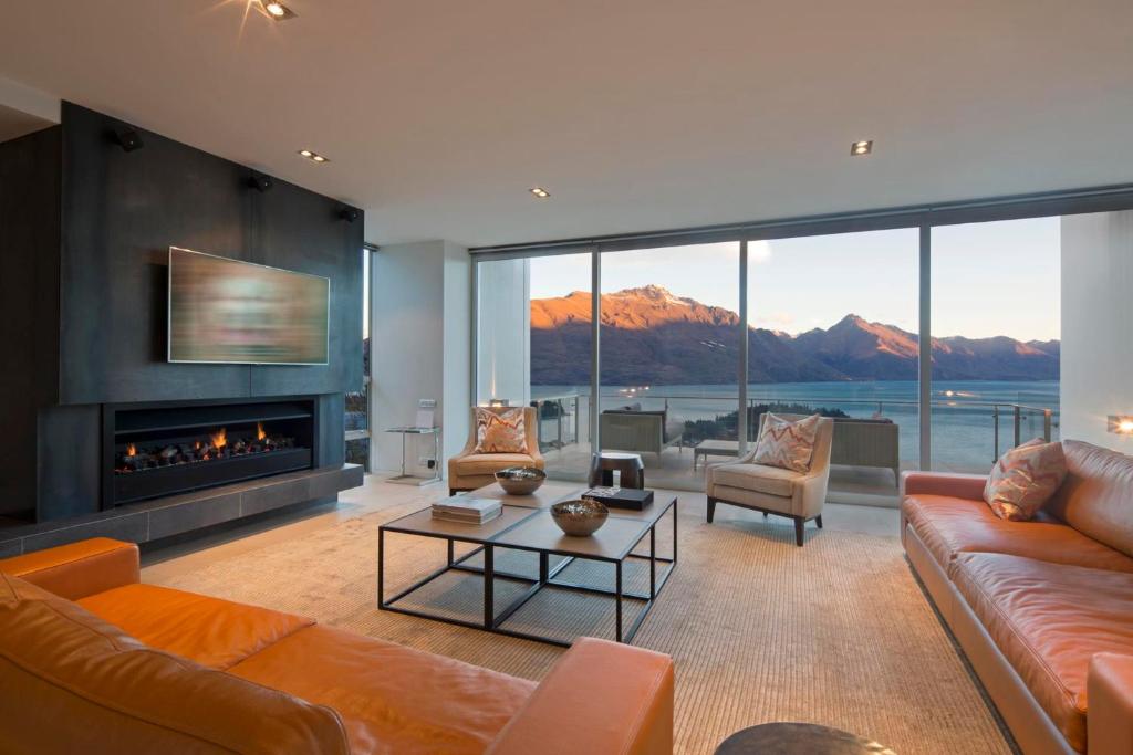 a living room with a couch and a fireplace at Villa De Luxe, a Relax it's Done luxury holiday home in Queenstown