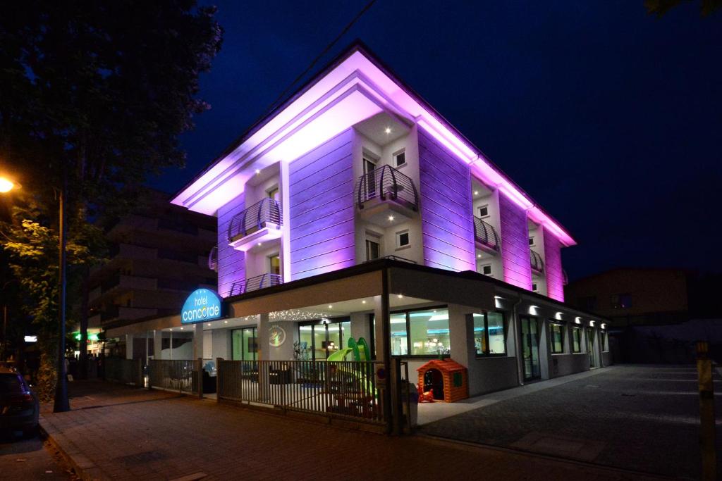 um edifício com iluminação roxa na lateral em Hotel Concorde em Cesenatico