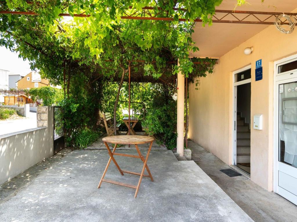 a chair sitting under a tree next to a building at Simplistic Holiday Home in Rogoznica near the Seabeach in Rogoznica