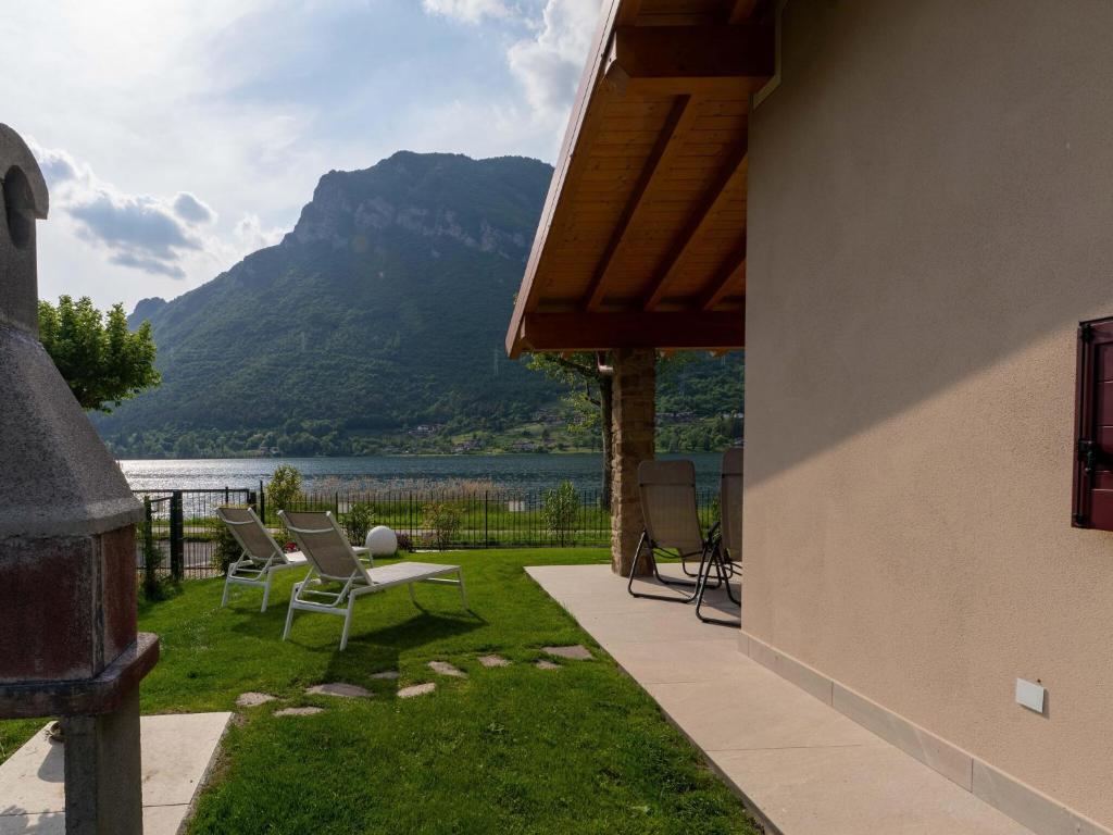 a patio with chairs and a view of a mountain at Idyllic cottage next to the beautiful Lake Idro in Crone