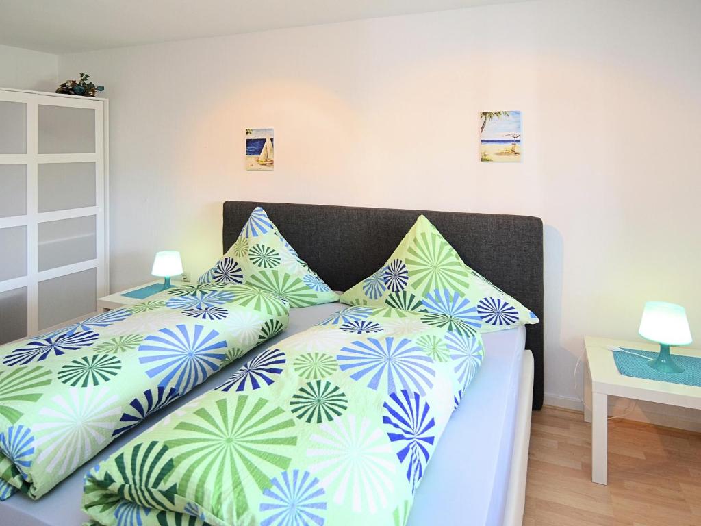 a bedroom with a bed with blue and green pillows at Luxurious Apartment in Medebach near public pool in Medebach