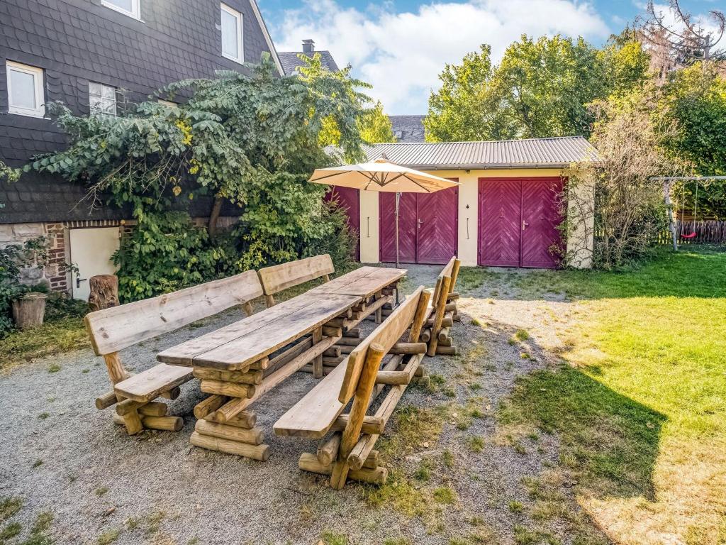 a wooden picnic table with an umbrella in a yard at Ferienhaus in Medebach nahe Skigebiet in Medebach