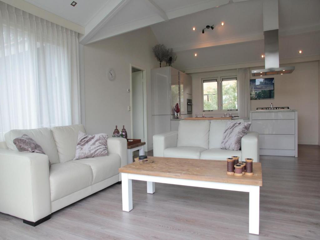 a living room with two white couches and a coffee table at Lovely Holiday Home in Kattendijke near Centre in Kattendijke