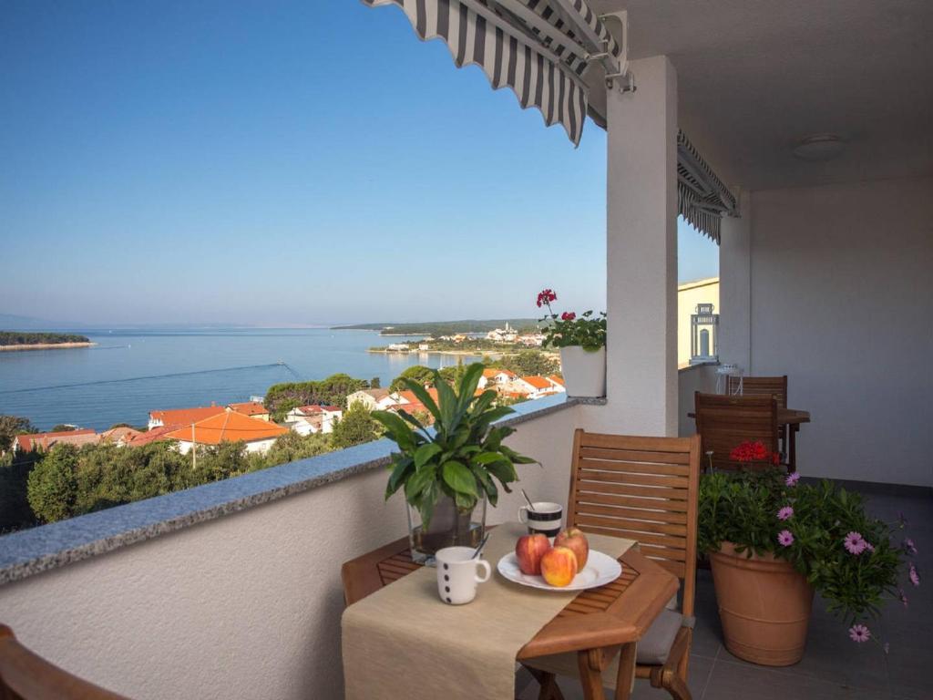 balcón con mesa y vistas al océano en Guest house Mazuth en Rab