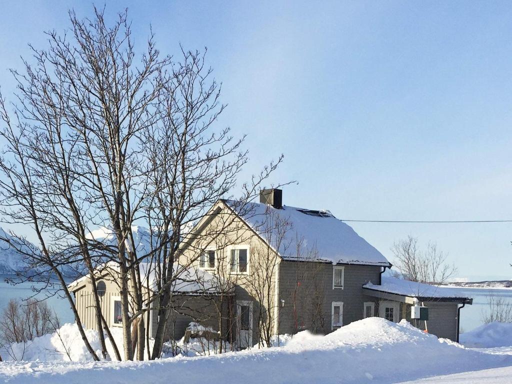 een oud huis in de sneeuw met een boom bij 6 person holiday home in Olderdalen in Olderdalen