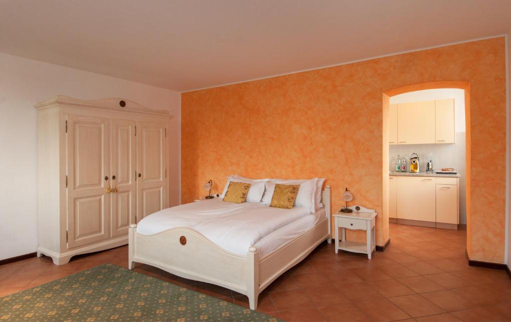 een slaapkamer met een wit bed en een oranje muur bij Vecchia Osteria Seseglio in Chiasso