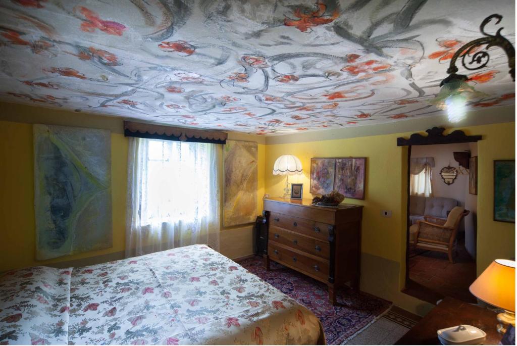 a bedroom with a bed and a ceiling with fish on it at Al Museo in Ponte