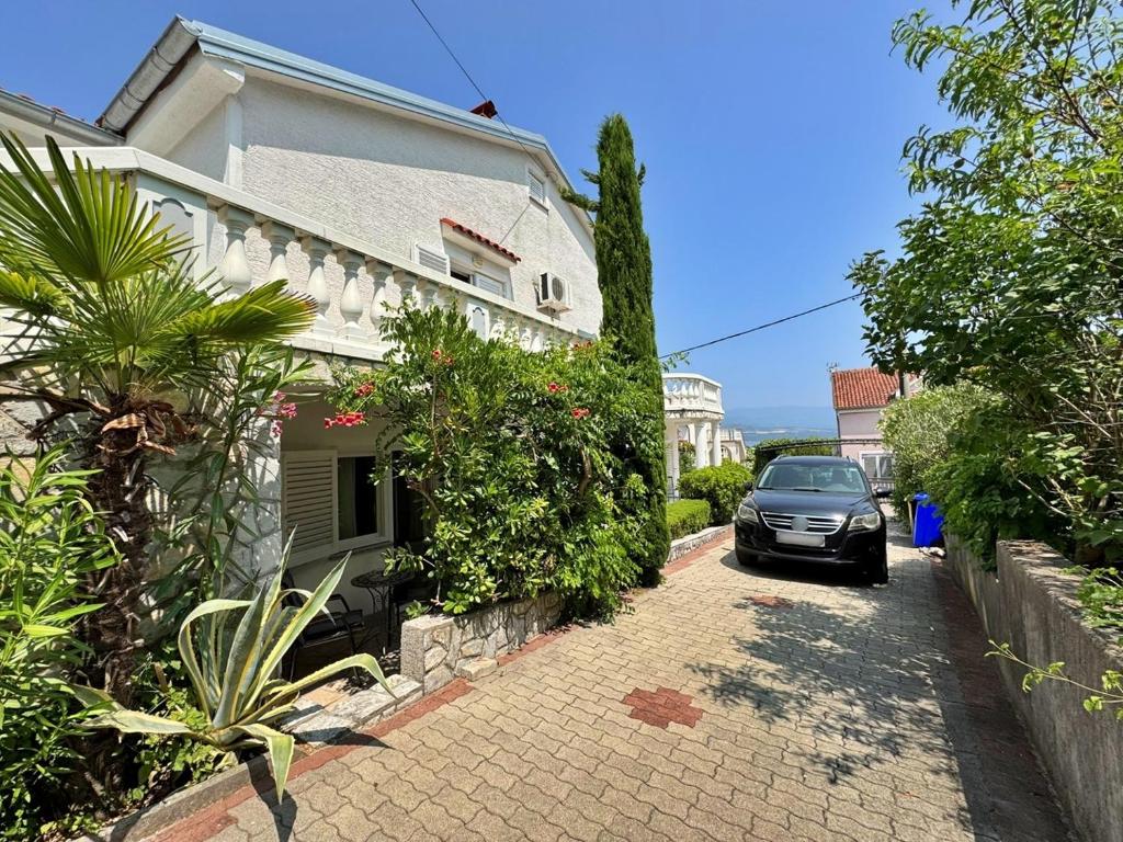 une voiture garée devant une maison dans l'établissement Apartments Zlatica, à Šilo