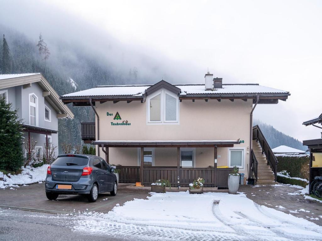 a car parked in front of a house in the snow at Pretty Apartment in Hollersbach near forest in Hollersbach im Pinzgau