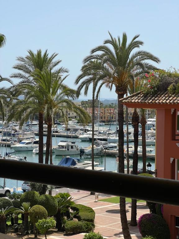 a view of a marina with palm trees and boats at Apartamento Puerto Sotogrande Marina in Sotogrande