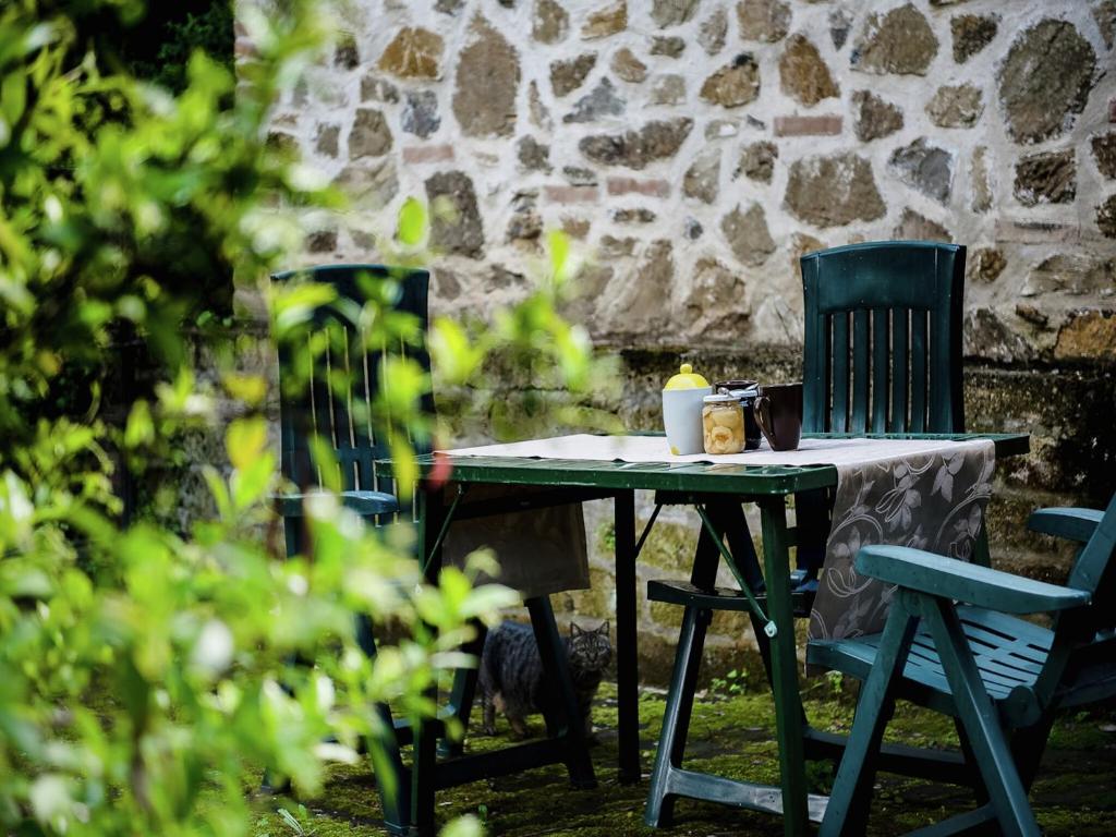 a table with a chair and a table with a candle on it at Holiday Home in Paciano with Swimming Pool,Terrace,Billiards in Paciano