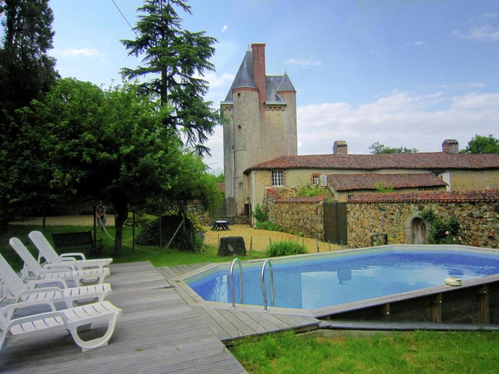 a swimming pool in front of a building with a castle at Saint-Paul Pool Retreat in Saint-Paul-du-Bois