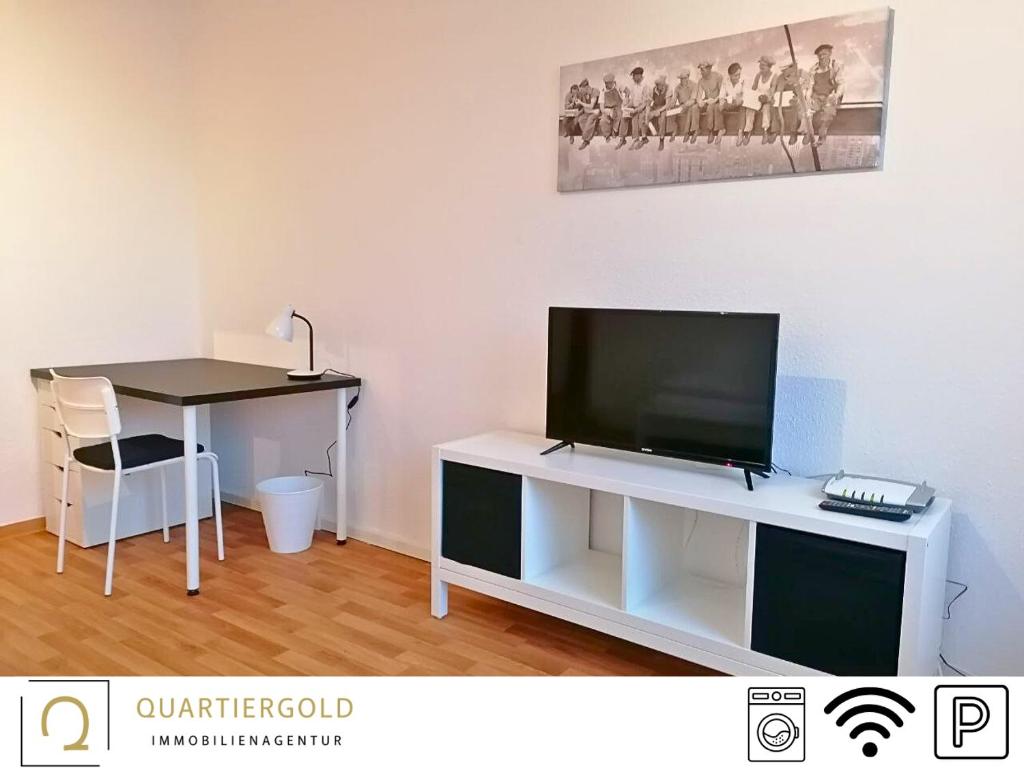 een woonkamer met een bureau en een televisie op een witte tafel bij Apartment I Business I Monteure in Lauchhammer
