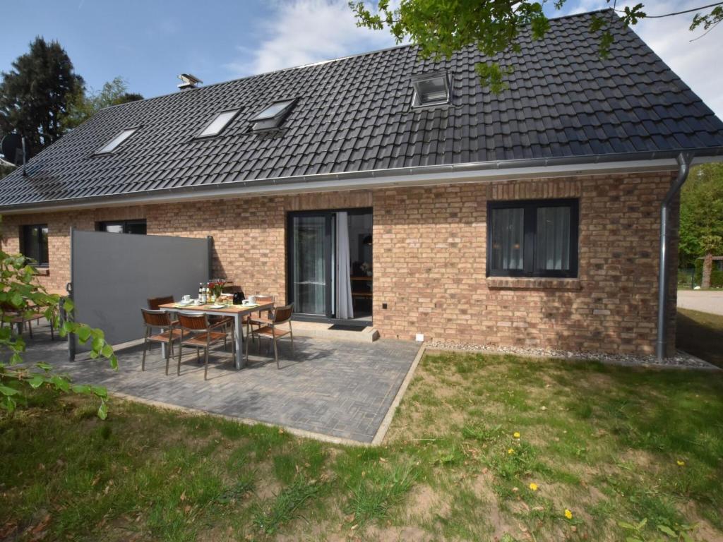 DamshagenにあるIdyllic Holiday Home in Damshagen with Terraceの家の前にテーブルと椅子が置かれたパティオ
