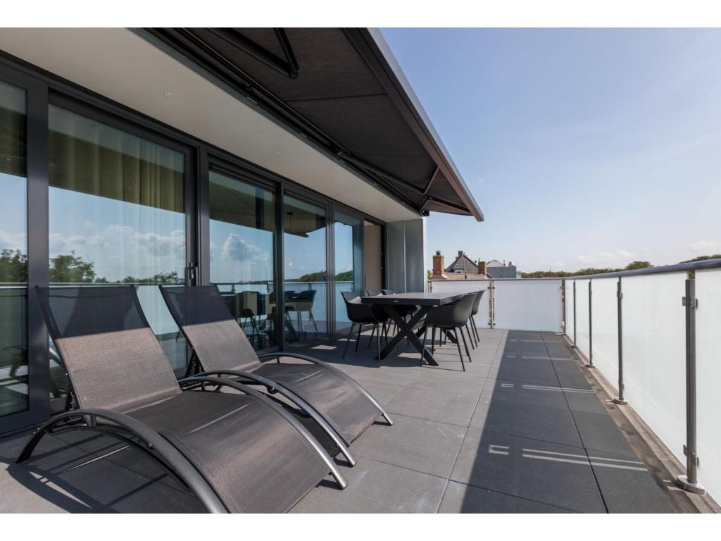 a patio with chairs and a table on a balcony at Appealing apartment in Domburg near the beach in Domburg