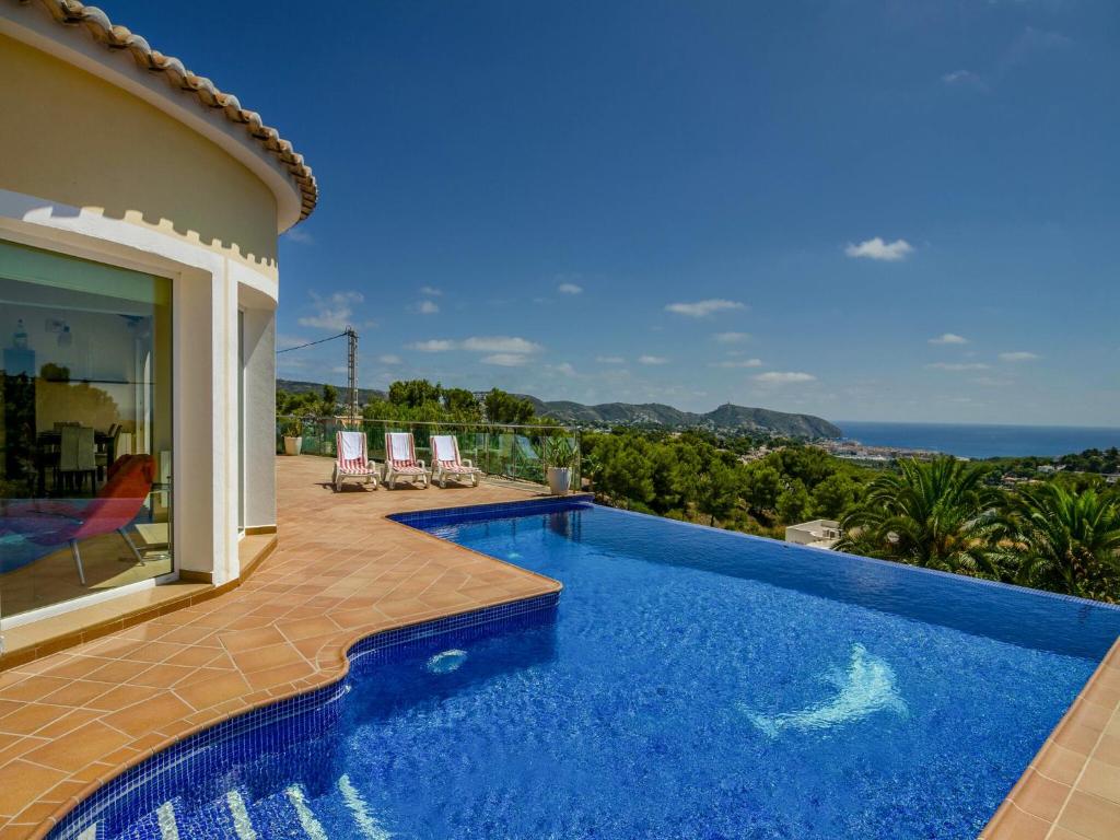a swimming pool with a view of the ocean from a house at Unique villa in Moraira with infinity pool in Moraira