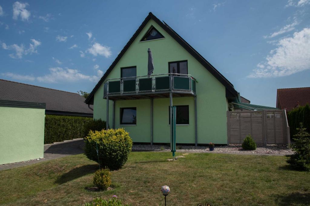 a green house with a balcony on top of it at Annabell in Kühlungsborn