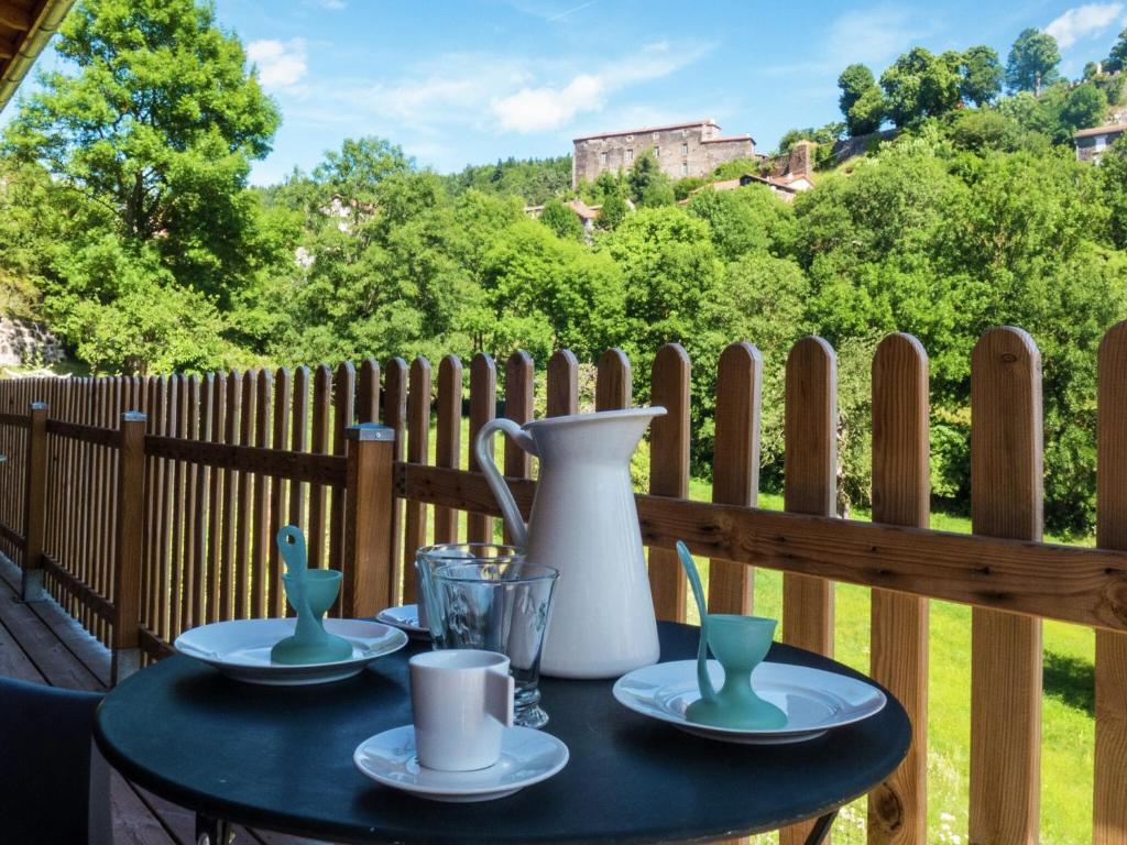 une table avec des assiettes et un vase sur une clôture dans l'établissement Cozy Countryside Escape in Auvergne, à Vachelerie
