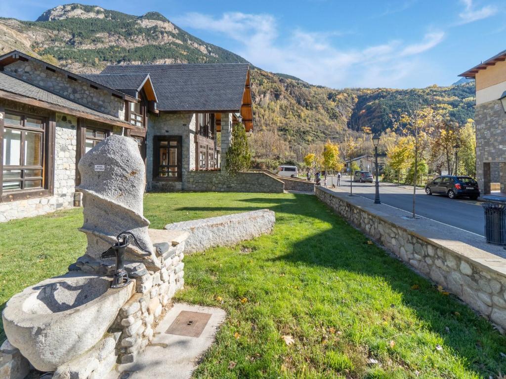 a stone wall in front of a house with a mountain at NATUSliving Benasque E in Benasque