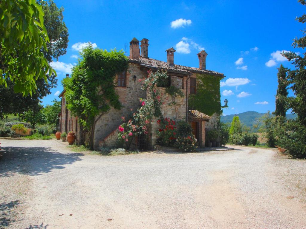 an old house with flowers on the side of it at Exquisite Villa in San Venanzo with Private Pool in San Venanzo