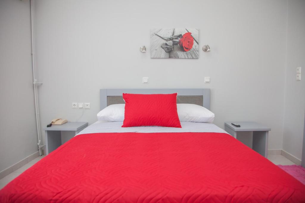 a red bed with a red pillow on top of it at Melissi in Lefkada Town