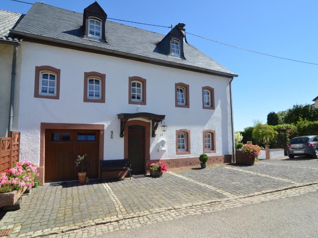a large white house with a driveway at Appealing Apartment in Ittel with Garden, Parking, Bicycles in Welschbillig