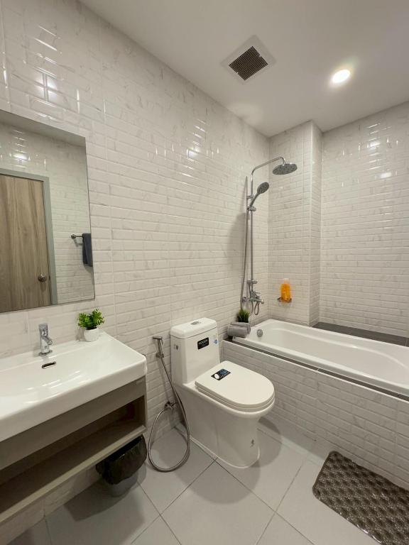 a bathroom with a toilet and a sink and a tub at ไรท์ อพาร์ทเม้นท บาย กู๊ดดี in Ban Liap