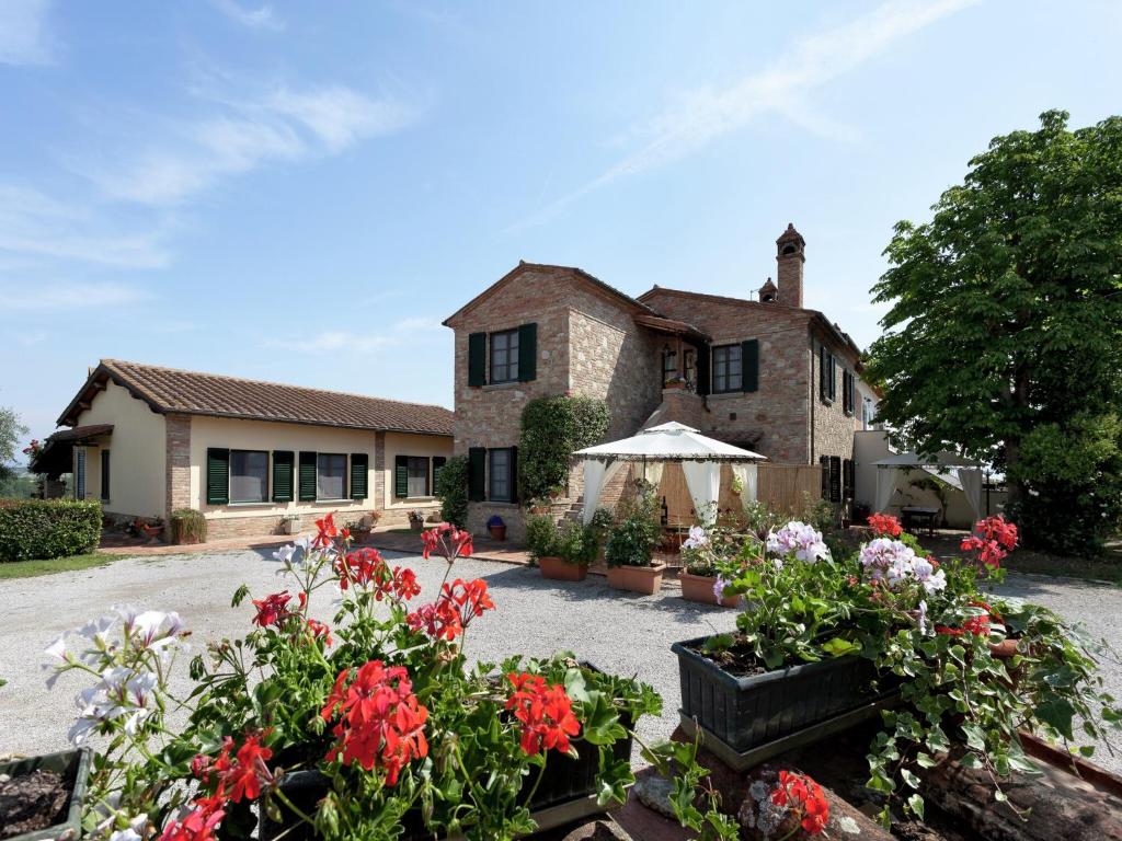 a house with flowers in front of it at Modern Holiday Home in Foiano della Chiana with Pool in Foiano della Chiana