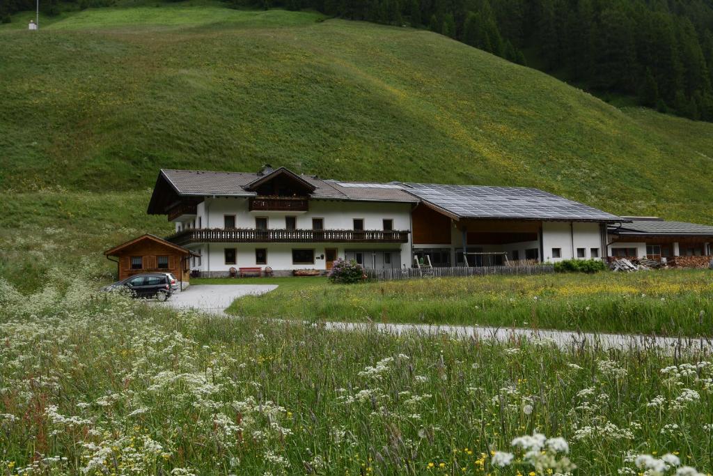 a house on a hill with a car parked in front at Boarhof in San Giacomo Val di Vizze