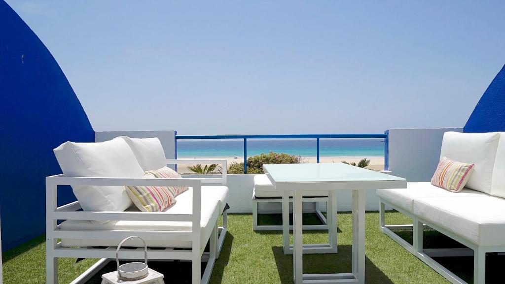 einen Balkon mit einem Tisch, Stühlen und Meerblick in der Unterkunft Lances Beach Penthouses in Tarifa