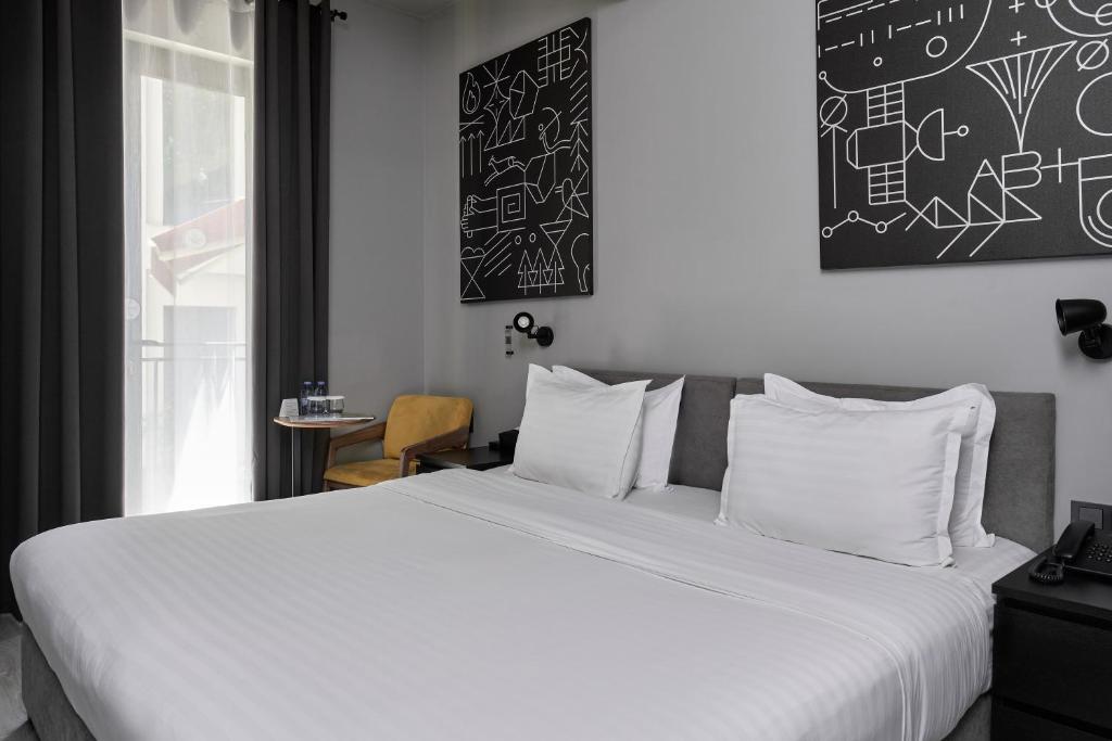 ein Schlafzimmer mit einem großen Bett mit weißer Bettwäsche in der Unterkunft Sapiens Hotel in Taschkent
