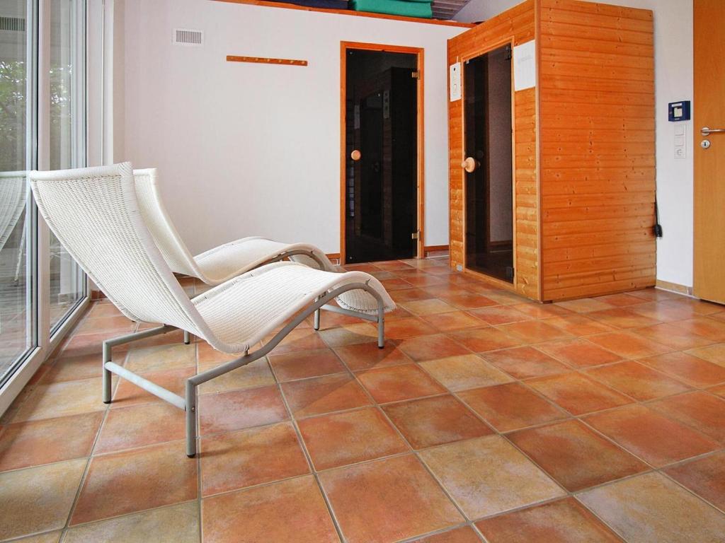 a white chair sitting on a tiled floor in a room at Holiday resort in the Müritz National Park, Mirow in Mirow