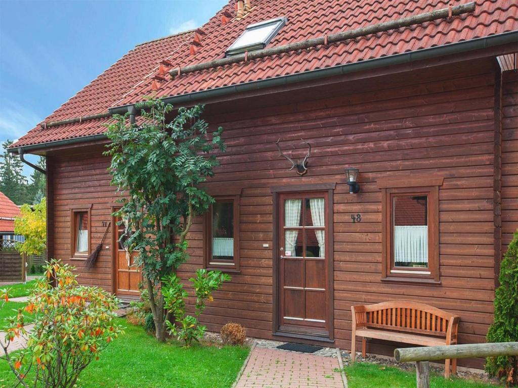 une maison en bois avec un banc devant elle dans l'établissement Holiday home in Hasselfelde, à Hasselfelde