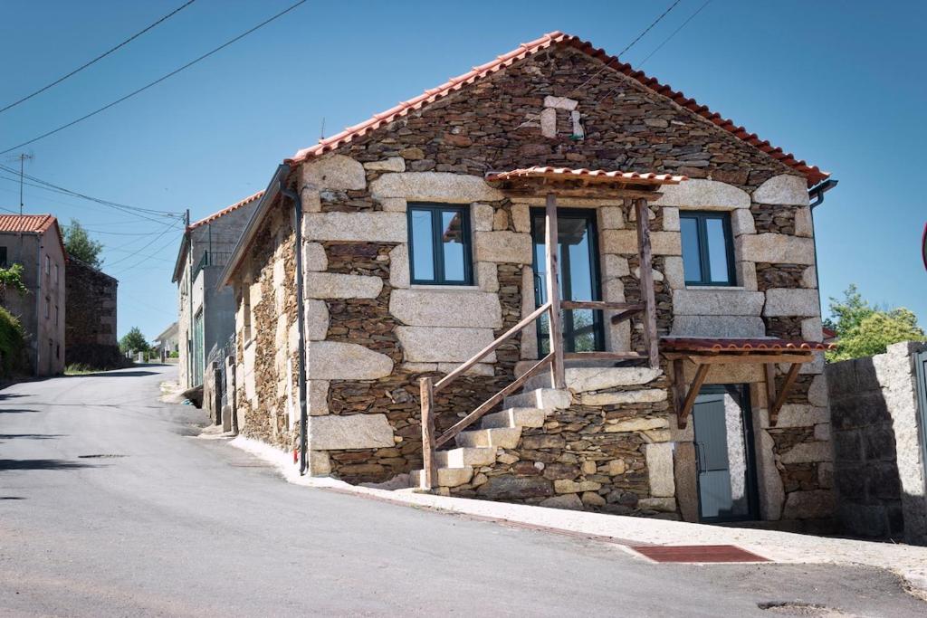 ein altes Steinhaus auf einer Straße in der Unterkunft Casa da Zurja in Guarda