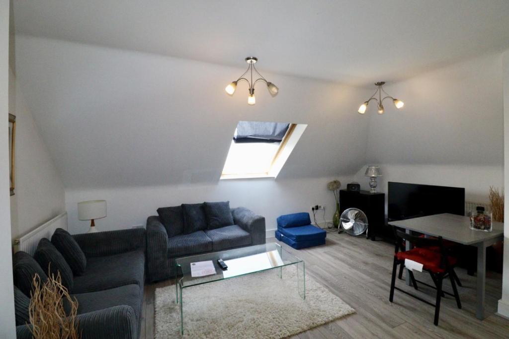 a living room with a couch and a table at Egham Modern Two Bedroom Apartment in Egham
