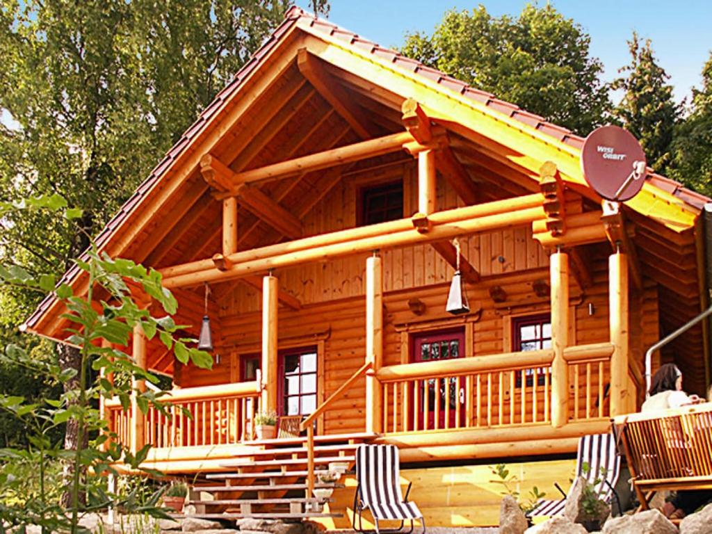 a large log cabin with a porch and a sign at Blockhaus mit Sauna und Kamin in Schierke in Schierke