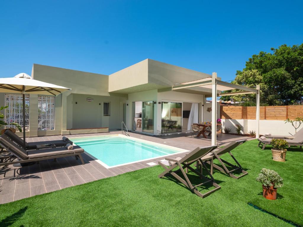a backyard with a swimming pool and a house at Gournes - NewTown Residences in Gournes