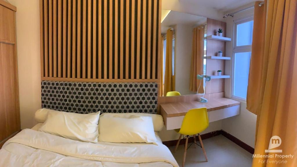 PampangにあるApartemen VidaView Unit 26D By Millproのベッドルーム1室(ベッド1台、デスク、黄色い椅子付)